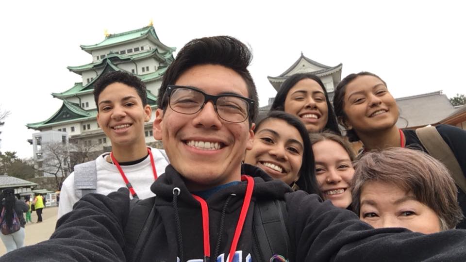 Students take selfie in front of historic buildings in Japan