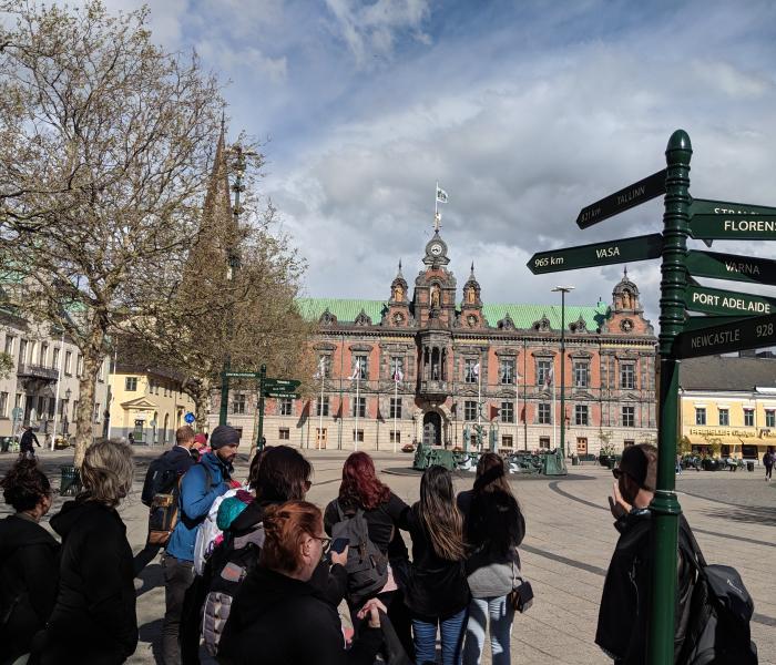 students standing in foreign city near sign post