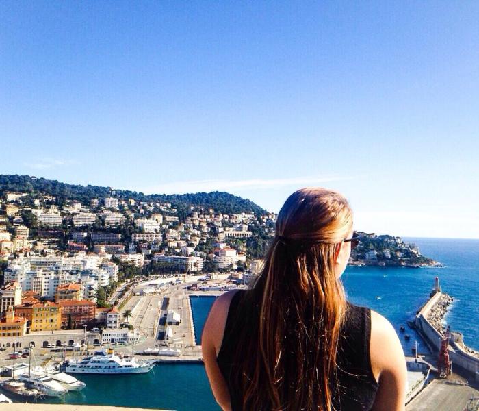 Study abroad student looks out over city and coast in Nice, France.