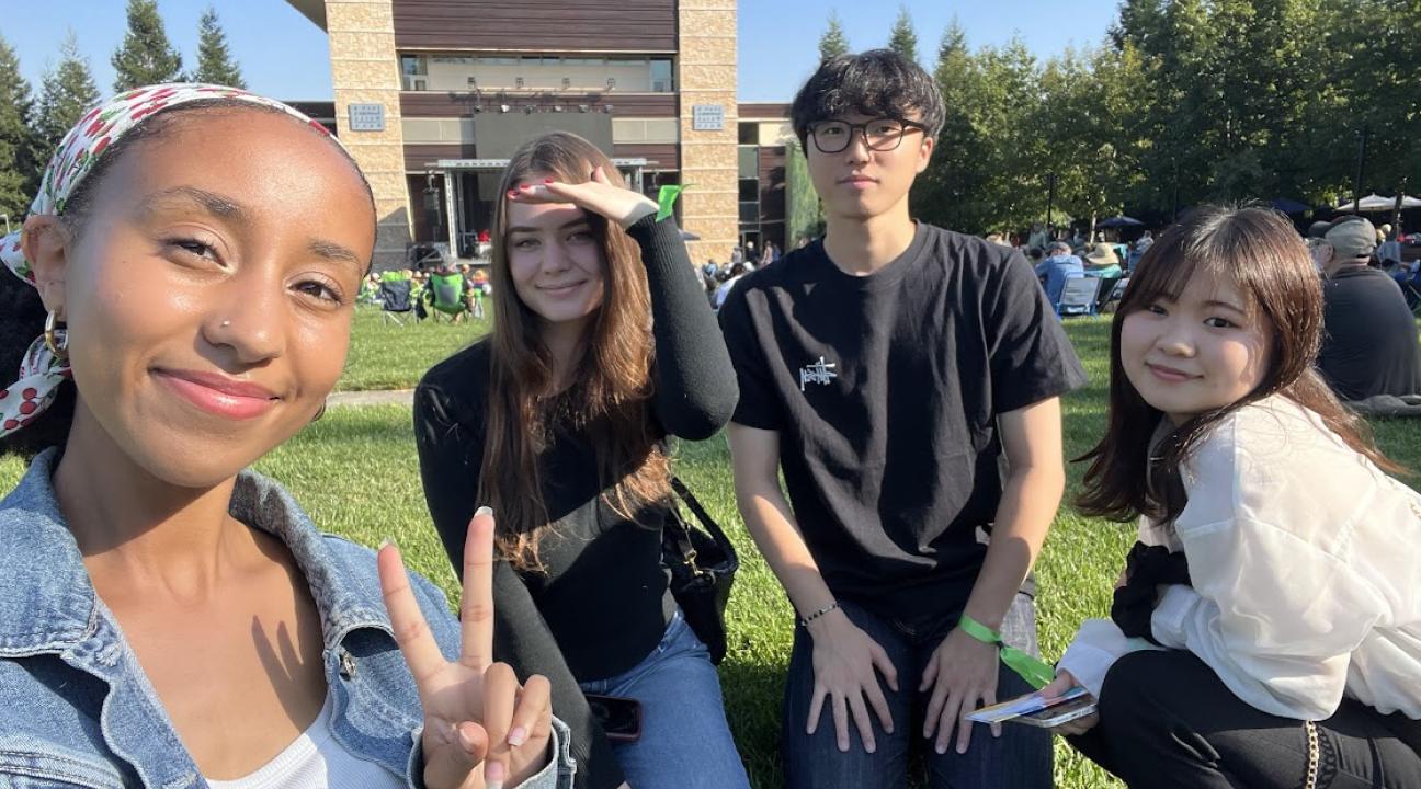 four students on the lawn at the green music center