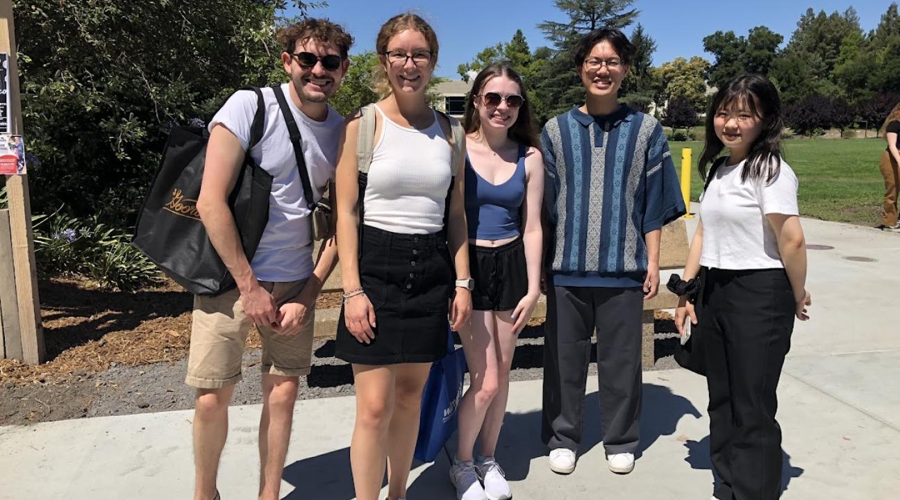 five students out on a sunny day smiling