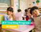 Photo of toddlers eating at a table togther at a pre-school of sorts; text reads "JET Teaching Progr