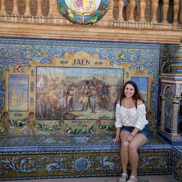 Tessa sits in front of mosaic wall in Spain