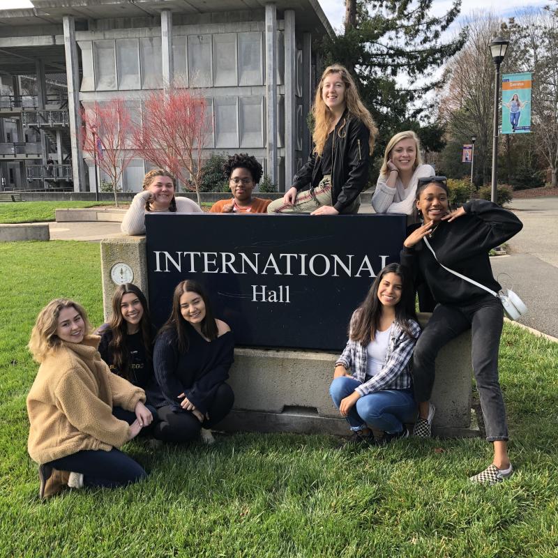 Students stand around International Hall sign