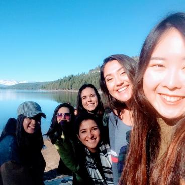 Students smiling by lake.