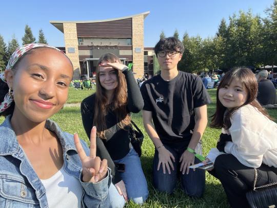 four students on the lawn at the green music center