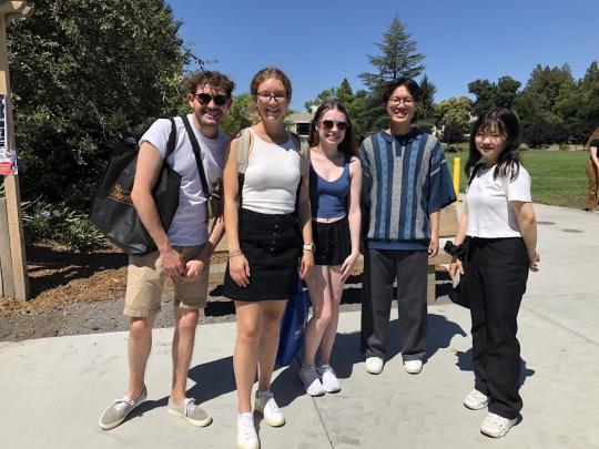 five students out on a sunny day smiling